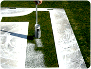 Aerosol white spray paint sprayed with hand wand for Football Field Number Stencil.
